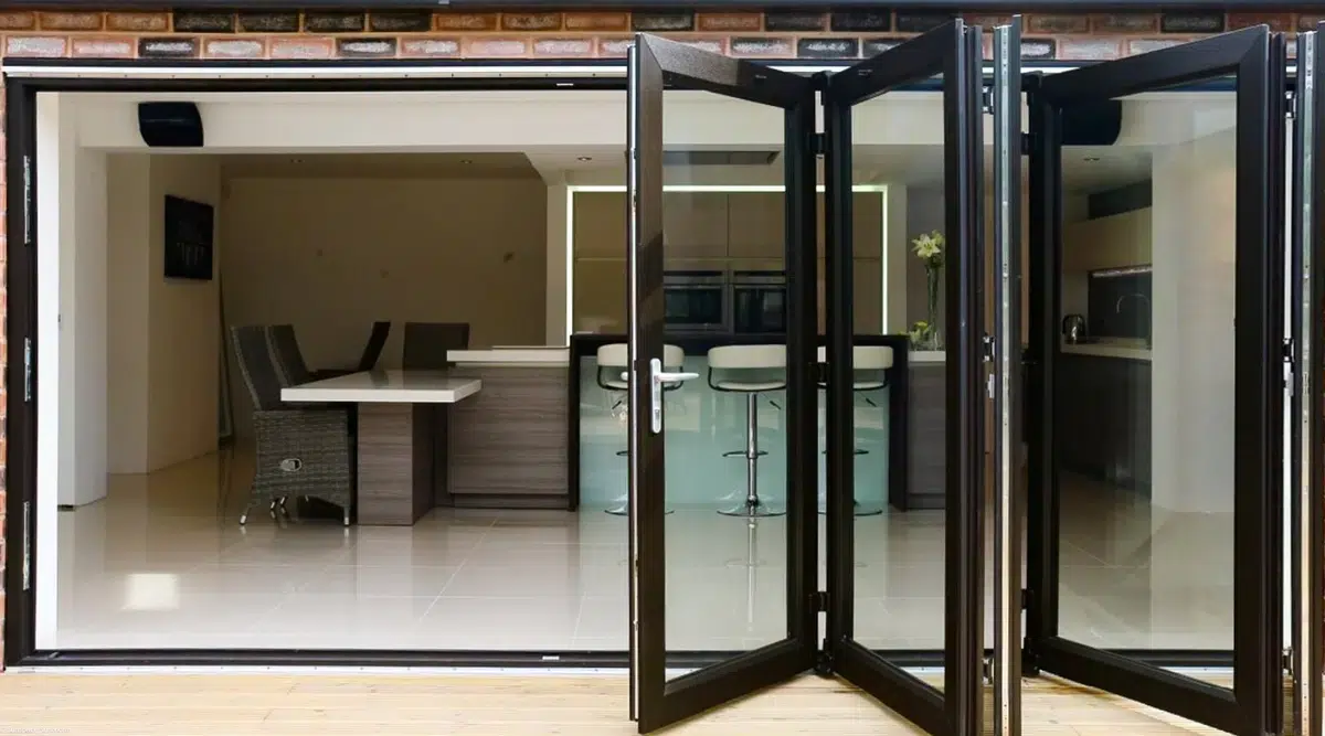 Open WeatherMaster Plus bi-fold door system installed in a modern sunroom.