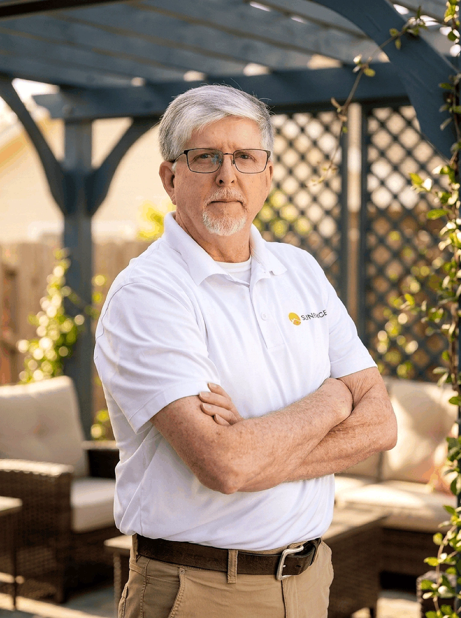 Keith Carter, Sunspace South Atlanta, posing outdoors with arms crossed in a branded white polo shirt and glasses.